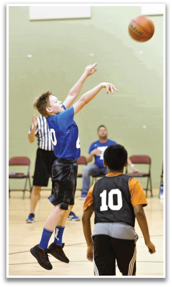 A boy in a blue shirt jumps to catch a basketball. AI generated content
