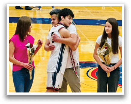 Two men hugging on a basketball court with a girl and a woman watching. AI generated content