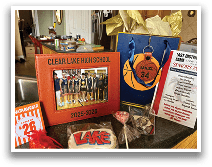 A display of Lake High School memorabilia, including a basketball, a book, and a candy bar, sits on a counter. AI generated content