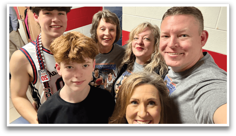 A group of people, including a man and a woman, are posing for a picture. They are all wearing shirts and are smiling for the camera. AI generated content