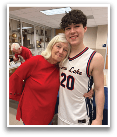 A man and woman are hugging each other. The woman is wearing a red shirt and the man is wearing a white and blue basketball jersey. AI generated content