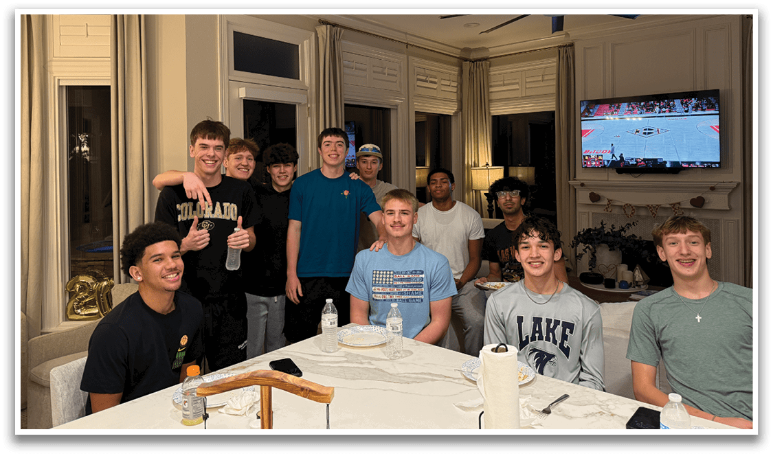 A group of young men are sitting around a dining table, enjoying a meal together. AI generated content