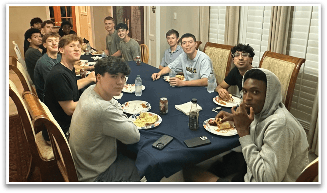 A group of people are sitting around a table, eating food and drinking soda. AI generated content