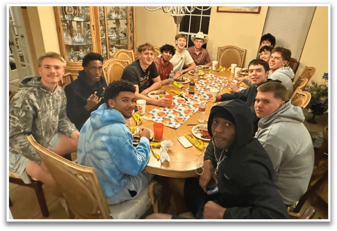 A group of people are sitting around a dining table, enjoying a meal together. AI generated content