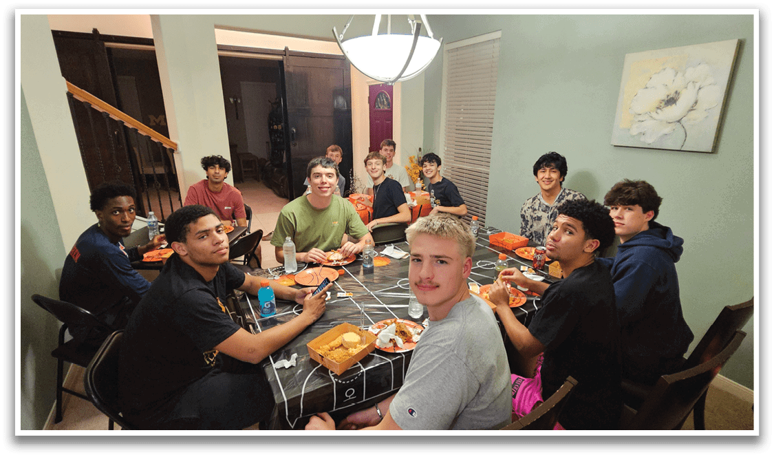 A group of people are sitting around a table, eating pizza and drinking from cups. AI generated content