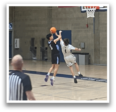 Basketball players on a court, one player is attempting to block a shot. AI generated content
