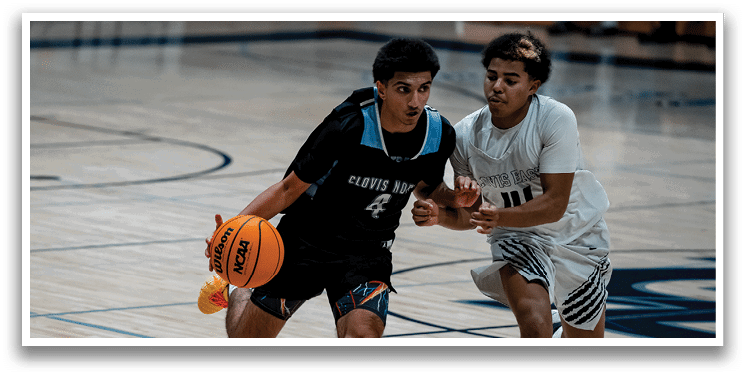 Two basketball players on a court, one holding a ball and the other trying to block him. AI generated content
