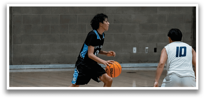 Two men playing basketball on a court, one wearing a blue shirt and the other wearing a white shirt. AI generated content