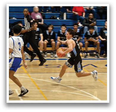A group of people are playing basketball on a court. One player is running with a basketball, while others are watching from the sidelines. AI generated content