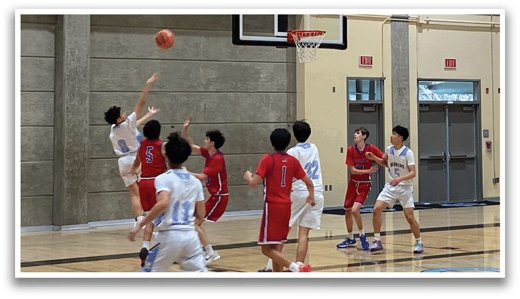 A basketball game is taking place in a gym. A player is in the air, attempting to shoot the ball. The gym is filled with spectators, and there are several chairs and benches arranged for them to sit on. The atmosphere is lively and competitive. AI generated content