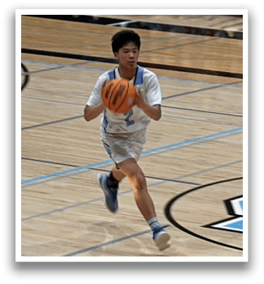 A man in a white shirt and blue shorts is running on a basketball court, holding a basketball in his hand. AI generated content