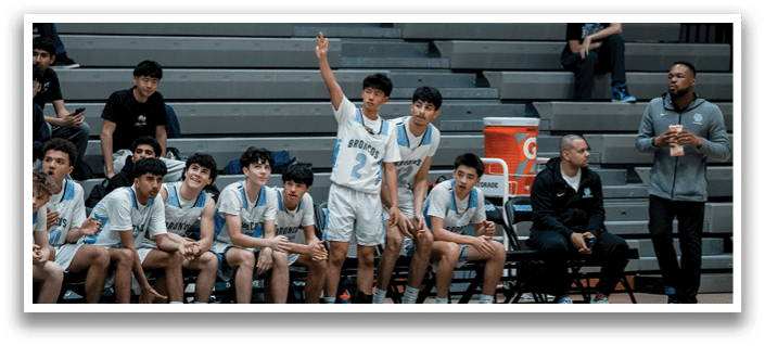 A group of young men are sitting on a bench, watching a game. AI generated content