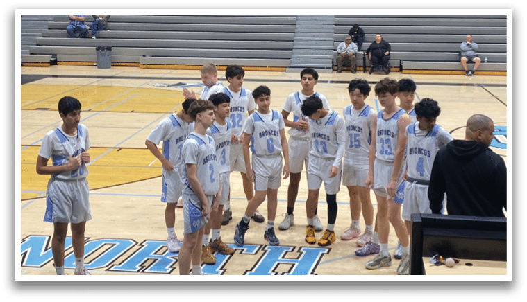 A group of young men wearing blue and white uniforms are standing on a basketball court. AI generated content