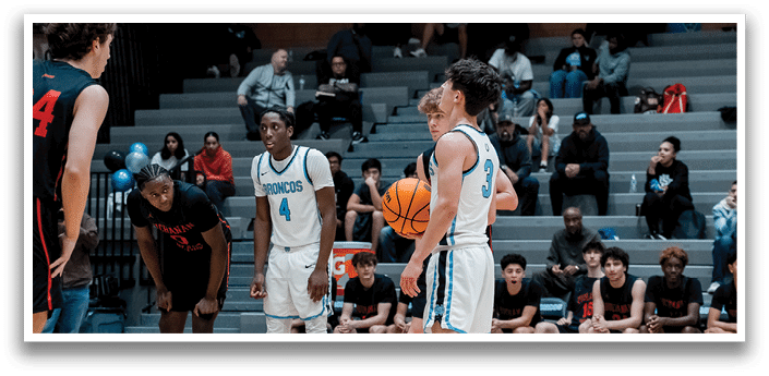 A group of young men playing basketball on a court with a crowd watching. AI generated content