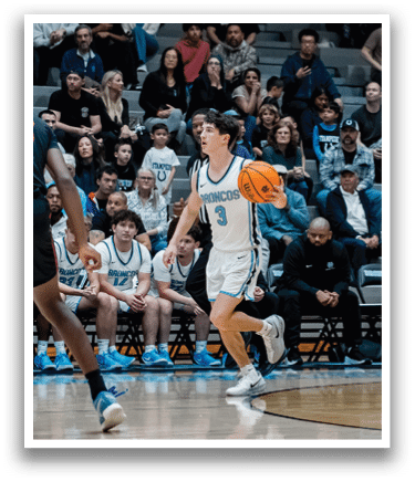 A basketball game is taking place with a player in a white uniform holding the ball. The crowd is watching the game intently. AI generated content