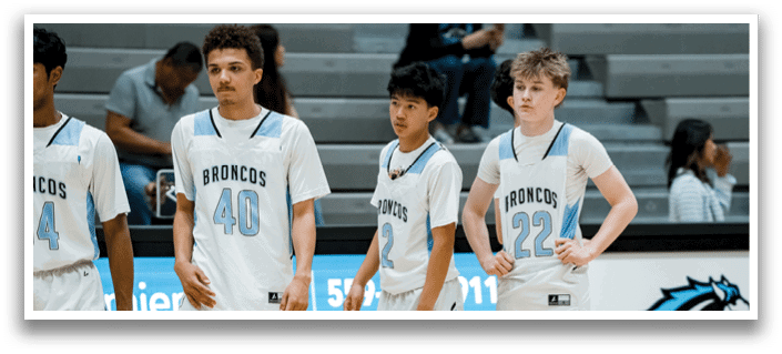 Four young men wearing white jerseys with the number 44, 22, 4, and 47 stand on a basketball court. AI generated content