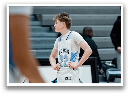 A boy wearing a basketball uniform stands on a basketball court. AI generated content
