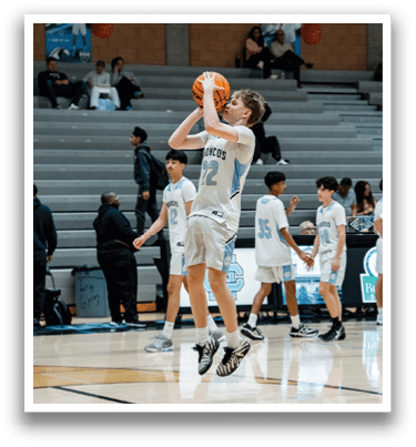 A basketball player in a blue and white uniform jumps to catch the ball. AI generated content