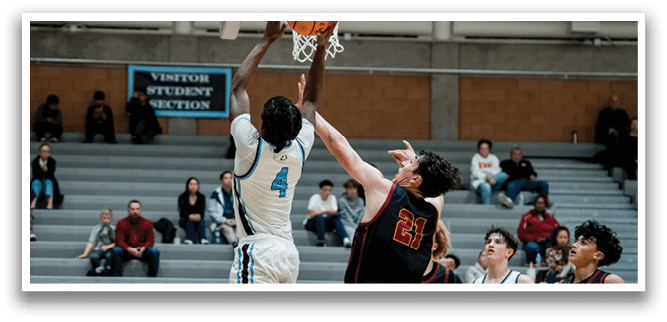 Two basketball players are fighting for a rebound, with one player jumping in the air to grab the ball. AI generated content