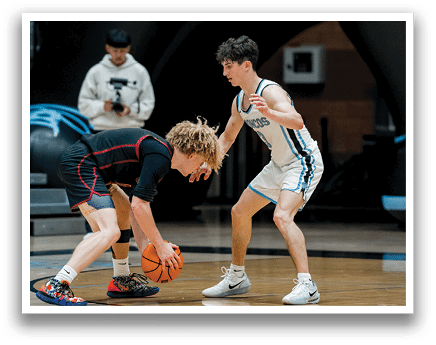Two boys are playing basketball on a court. One boy is holding a basketball and the other is trying to take it from him. AI generated content