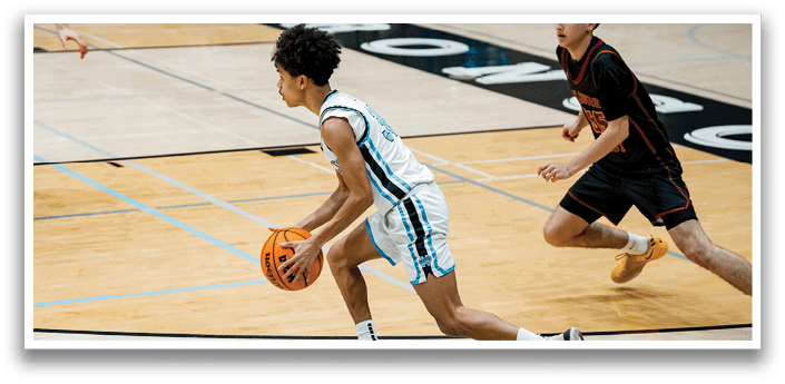 Two basketball players on a court, one holding a ball and the other running towards him. AI generated content