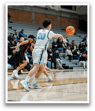 A basketball game is taking place with two teams playing. One player is attempting to shoot the ball while another player tries to block the shot. The crowd watches the game intently. AI generated content