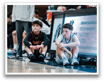 A group of young men are sitting on the floor in front of a scoreboard. AI generated content