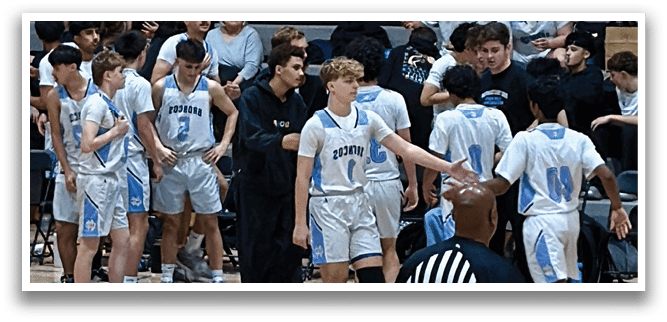 A group of young men in a gym, some wearing blue and white uniforms, are standing and talking to each other. AI generated content