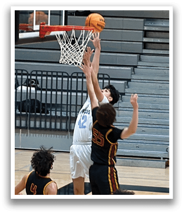 A basketball game is in progress with players on the court. One player is attempting to dunk the ball through the hoop. The game is being watched by several people, including a man in a black shirt and white hat. AI generated content