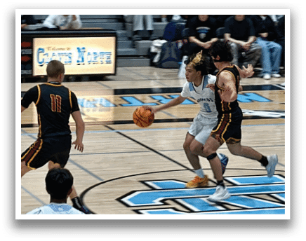 A basketball game is taking place with two teams playing against each other. One player is holding a basketball while another player is trying to block him. The crowd is watching the game intently. AI generated content