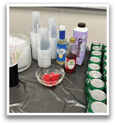 A table with a black tablecloth and a bowl of red candy on it. AI generated content