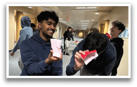 Two men are playing a video game in a hallway. One man is holding a game controller while the other man is holding a red object. AI generated content