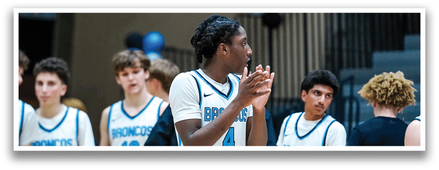 A group of young men wearing jerseys with the word “Broncos" on them are standing on a basketball court. AI generated content