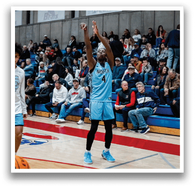 Two basketball players are on the court, one holding the ball and the other with his hand up. They are surrounded by a crowd of people watching the game. AI generated content