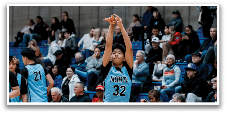A young man in a blue basketball uniform is holding a basketball in his hands, preparing to shoot it. AI generated content