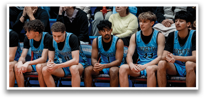 A group of young men wearing blue and black uniforms are sitting on a bench. AI generated content