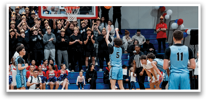 A basketball game is taking place with a player in a blue uniform attempting to shoot the ball. The crowd is watching intently as the player attempts to score. AI generated content