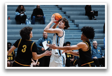 A basketball player in a white jersey is attempting to shoot the ball while two other players try to block him. The scene takes place in a gym with several people watching. AI generated content