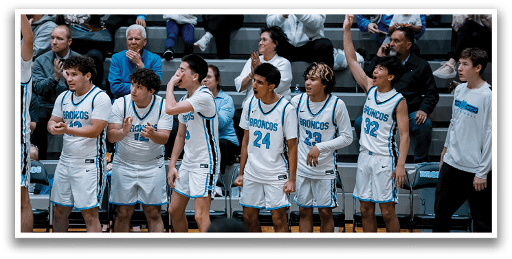 A group of basketball players on the court, with one player falling to the ground. The players are wearing blue and white uniforms. AI generated content
