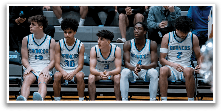 A group of young men are sitting on a bench, wearing sports uniforms. AI generated content