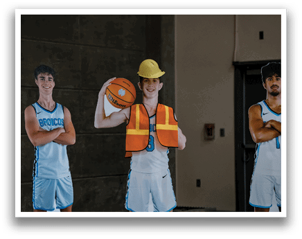 Three men pose in a garage, one wearing a hard hat and holding a basketball. AI generated content