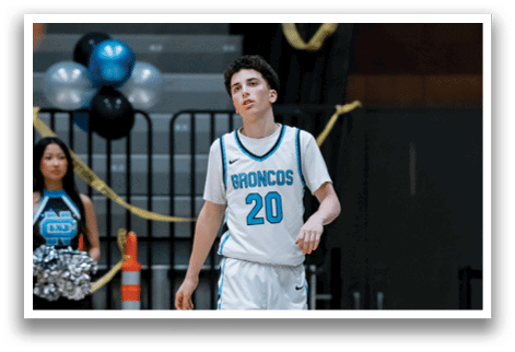 A boy in a blue and white uniform walks on a basketball court. AI generated content