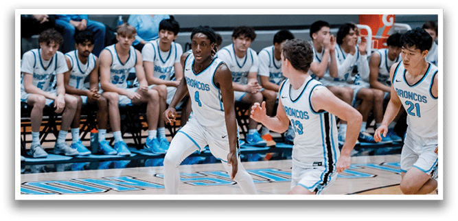 A basketball player is running with a ball, while other players watch from the sidelines. AI generated content