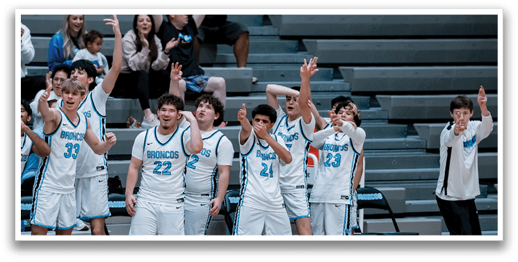 A group of young men wearing white uniforms are standing on a basketball court. They are holding up their hands in the air, possibly celebrating a victory or showing support for their teammates. The scene takes place in a gymnasium, with a bench visible in the background. AI generated content
