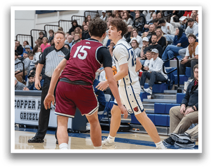 Two boys playing basketball on a court, one wearing a red jersey and the other wearing a white jersey. AI generated content