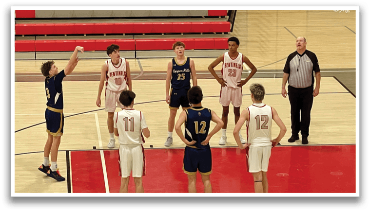 A group of basketball players are on the court, with one player in the air attempting to shoot the ball. The players are wearing uniforms and are in various positions on the court. There are several chairs placed around the court, likely for spectators. The scene appears to be taking place in a gymnasium. AI generated content