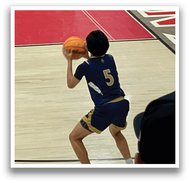 A boy in a blue shirt is playing basketball, holding a basketball in his hands. AI generated content