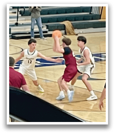 Three boys playing basketball on a court. One boy is holding a basketball, while the other two are trying to stop him. AI generated content