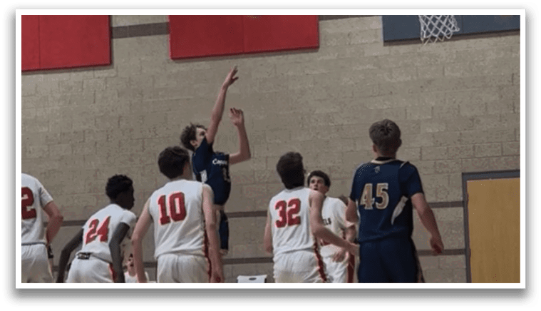 A group of young men playing basketball, with one player attempting to block a shot. AI generated content