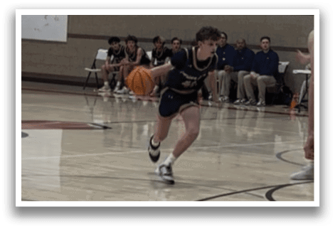 A basketball game is in progress with players on the court. A boy in a blue shirt is running with a basketball in his hand. AI generated content